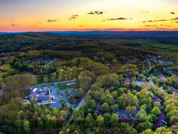 Aerial view of Warm Hearth Village and the surrounding forested hills in Blacksburg, Virginia at sunset
